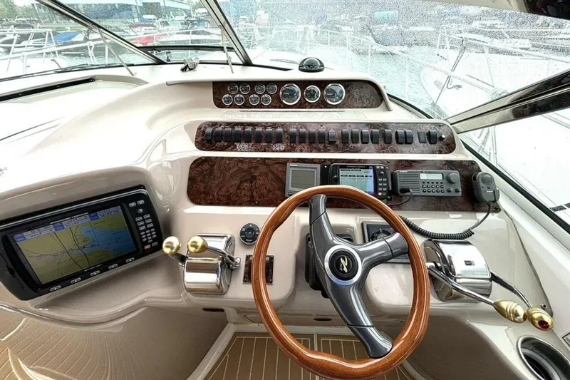 Yacht Photos Pics Cockpit of 1998 Sea Ray 400 Sundancer with navigation equipment and wooden steering wheel.