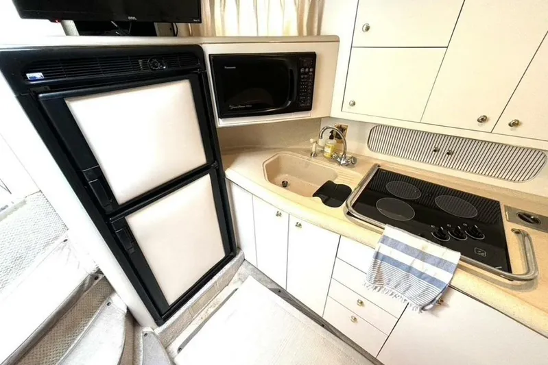  Yacht Photos Pics 1998 Sea Ray 400 Sundancer yacht kitchen with stove, sink, microwave, and refrigerator.