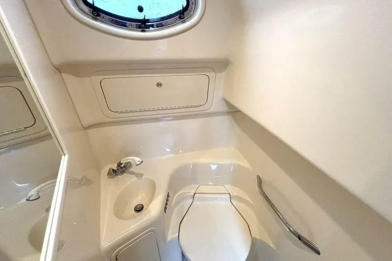  Yacht Photos Pics 1998 Sea Ray 400 Sundancer bathroom with sink, toilet, and porthole window.