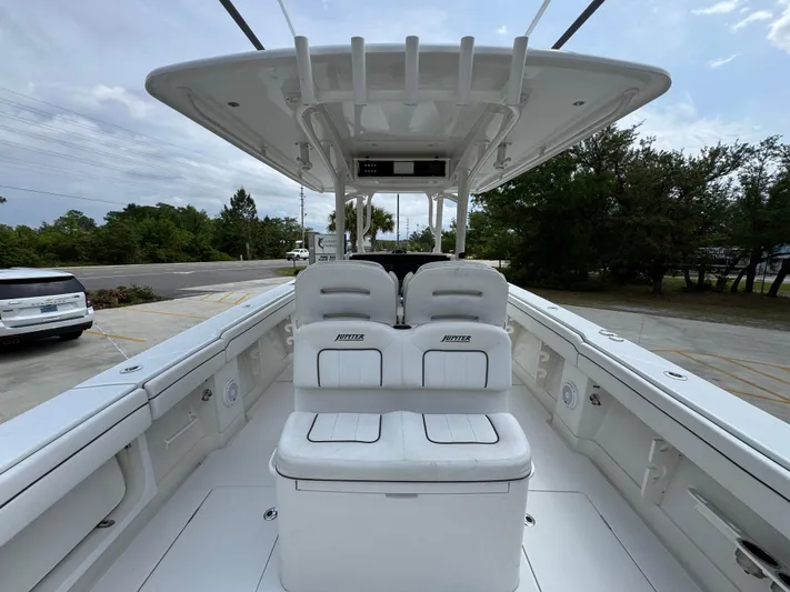  Yacht Photos Pics 2018 Jupiter 34 HFS boat interior with seating and console, docked outdoors.