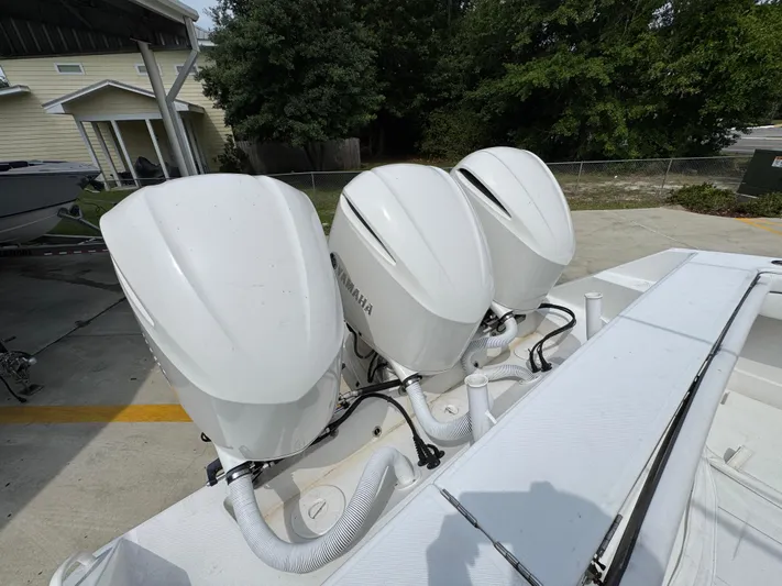  Yacht Photos Pics Triple outboard engines on a 2018 Jupiter 34 HFS boat, parked outdoors.