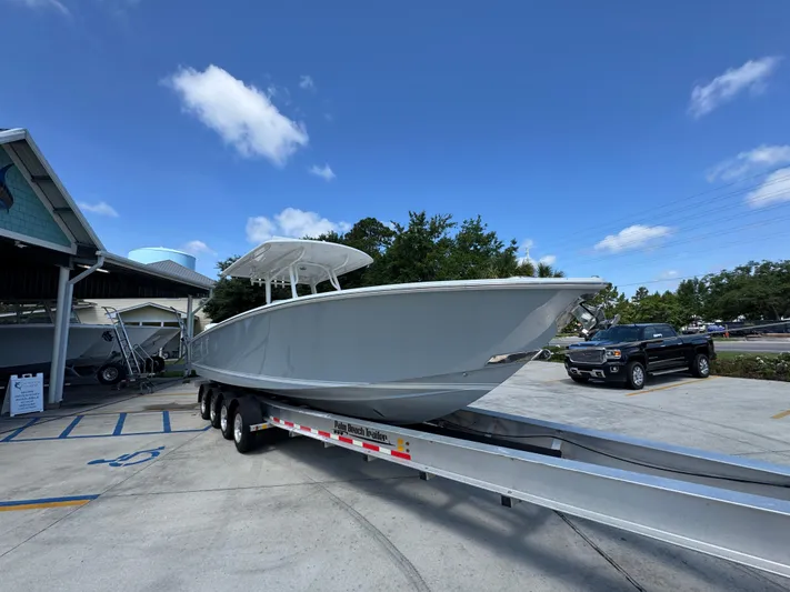  Yacht Photos Pics 2018 Jupiter 34 HFS boat on trailer in parking lot under clear blue sky.