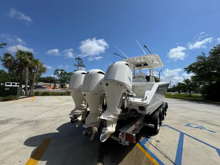  Yacht Photos Pics 2018 Jupiter 34 HFS boat with triple outboard engines on a trailer under a clear blue sky.