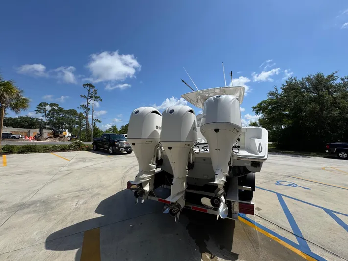  Yacht Photos Pics 2018 Jupiter 34 HFS boat with triple outboard engines in a parking lot.