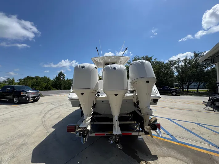 Yacht Photos Pics 2018 Jupiter 34 HFS boat with triple outboard engines in a sunny parking lot.