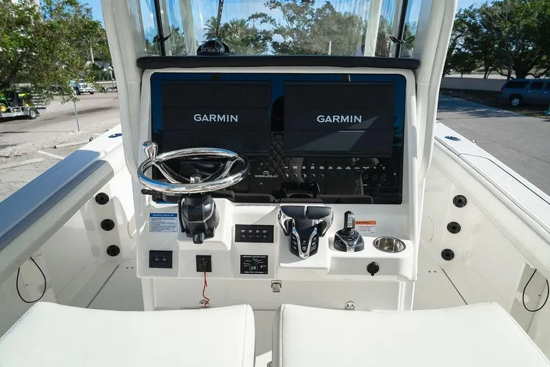  Yacht Photos Pics 2024 World Cat 295 CC boat dashboard with Garmin navigation displays and steering wheel.