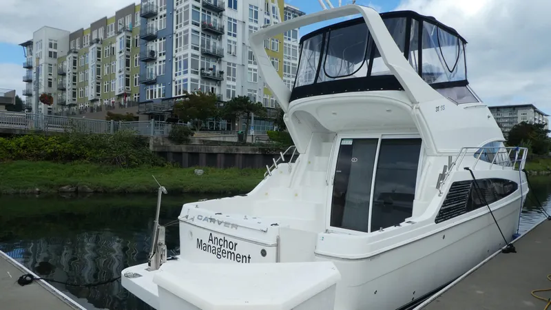  Yacht Photos Pics 2005 Carver 38 Super Sport yacht docked near modern apartments.