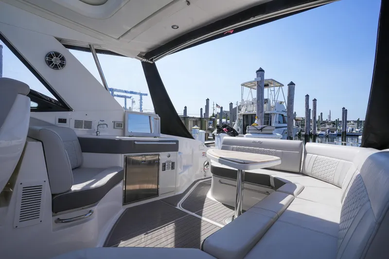  Yacht Photos Pics 2023 Sea Ray Sundancer 320 yacht interior with luxurious seating and marina view.