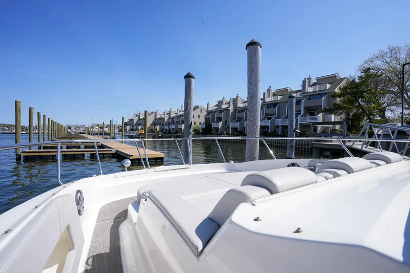  Yacht Photos Pics 2023 Sea Ray Sundancer 320 docked near waterfront homes under clear blue sky.