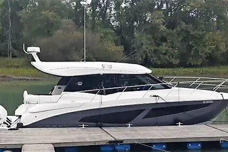  Yacht Photos Pics 2022 Regal 42 XO yacht docked by a serene, wooded shoreline.