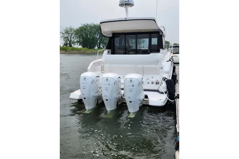  Yacht Photos Pics 2022 Regal 42 XO boat with triple outboard engines docked on water.