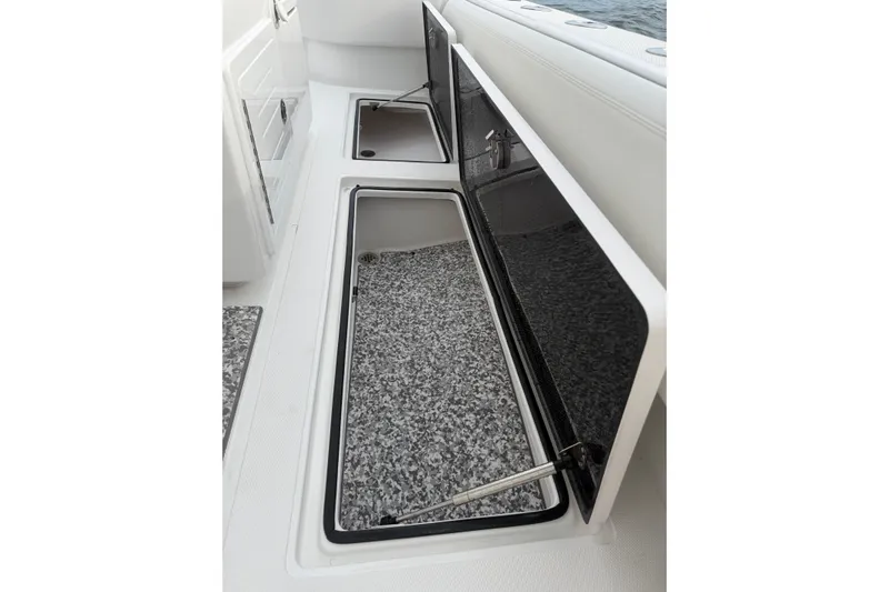  Yacht Photos Pics 2024 SeaHunter 28 Floridian boat storage compartments with open lids, showcasing interior space.