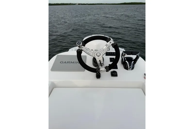  Yacht Photos Pics 2024 SeaHunter 28 Floridian helm with Garmin navigation, steering wheel, and throttle controls on open water.