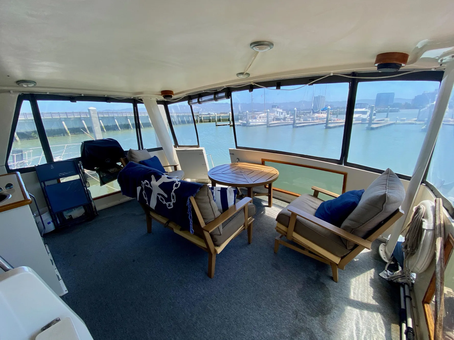 1988 Californian Sundeck Motoryacht interior with seating, table, and marina view.