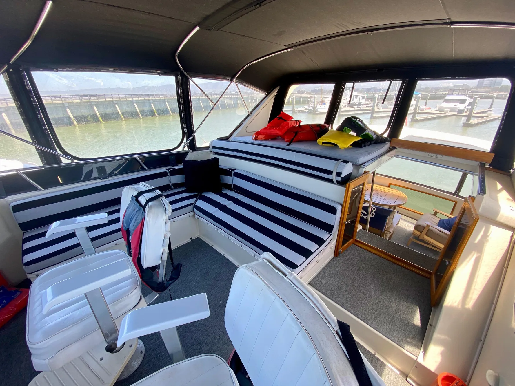 1988 Californian Sundeck Motoryacht interior with striped seating and marina view.