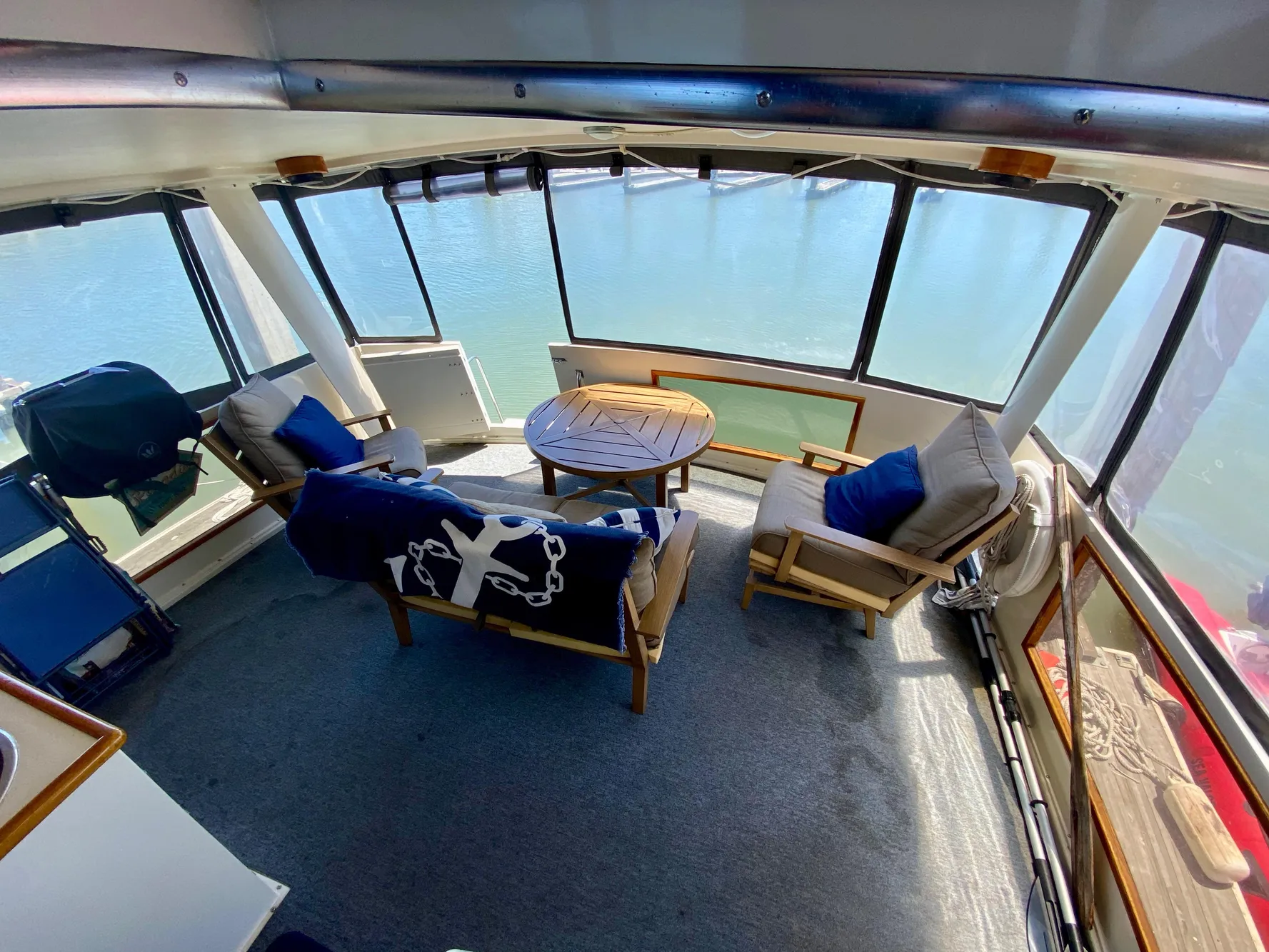 1988 Californian Sundeck Motoryacht interior with seating and table, overlooking water.
