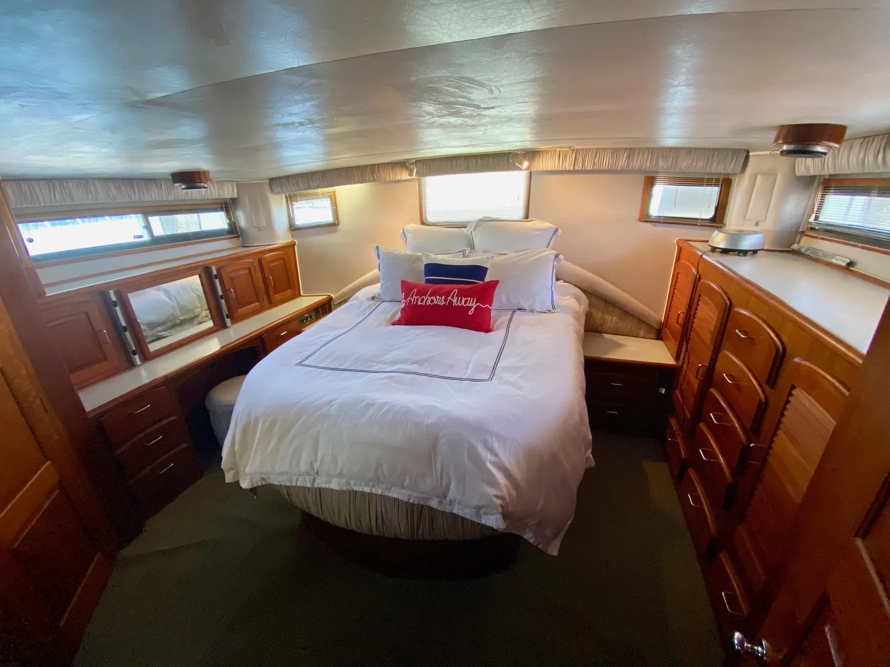 1988 Californian Sundeck Motoryacht bedroom with cozy bed and wooden cabinetry.