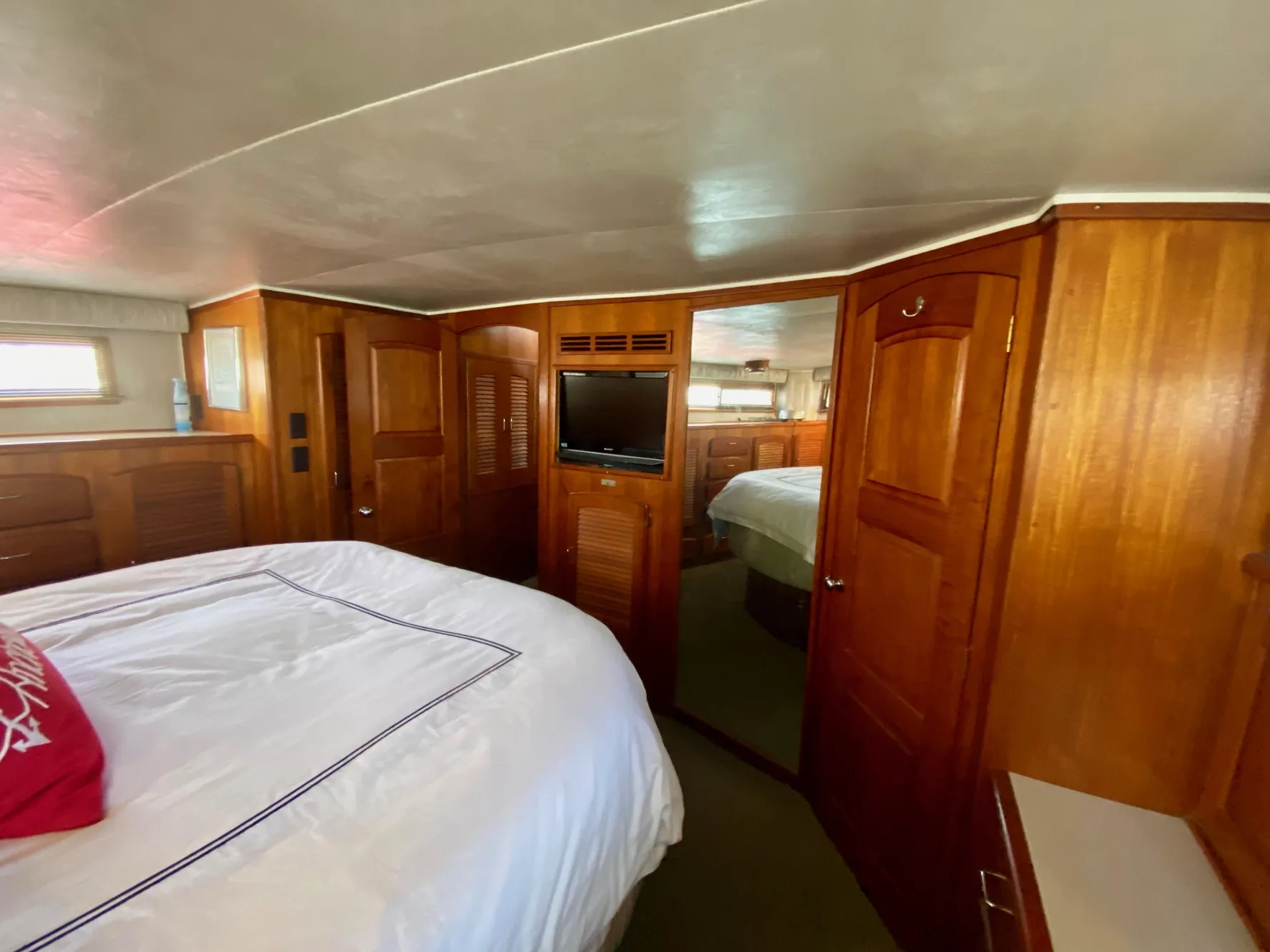 1988 Californian Sundeck Motoryacht bedroom with wooden interior and cozy bed.
