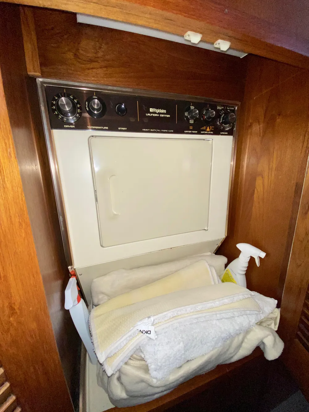 Laundry area with dryer in 1988 Californian Sundeck Motoryacht, featuring wooden cabinetry.