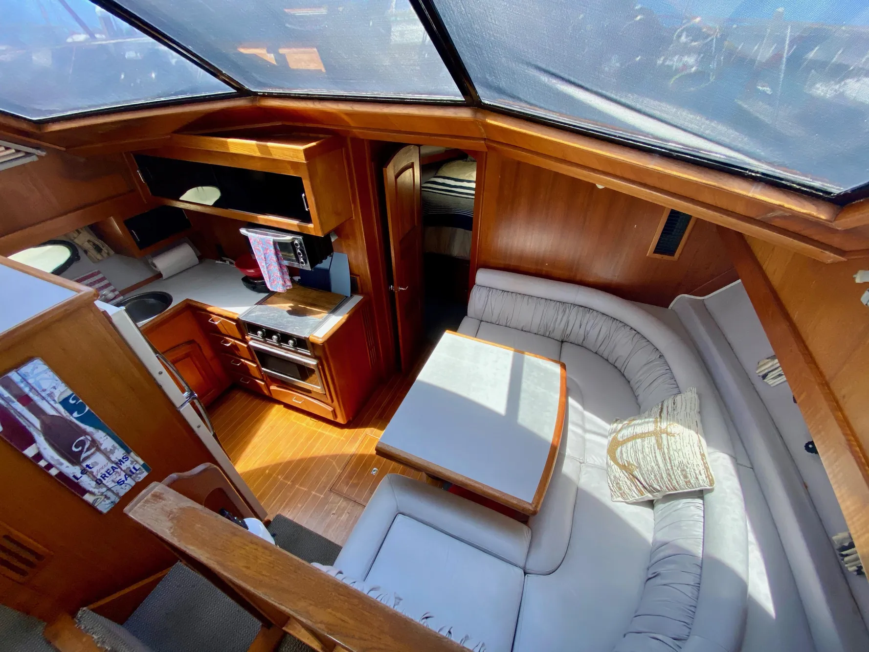 Interior of 1988 Californian Sundeck Motoryacht with cozy seating and kitchen area.