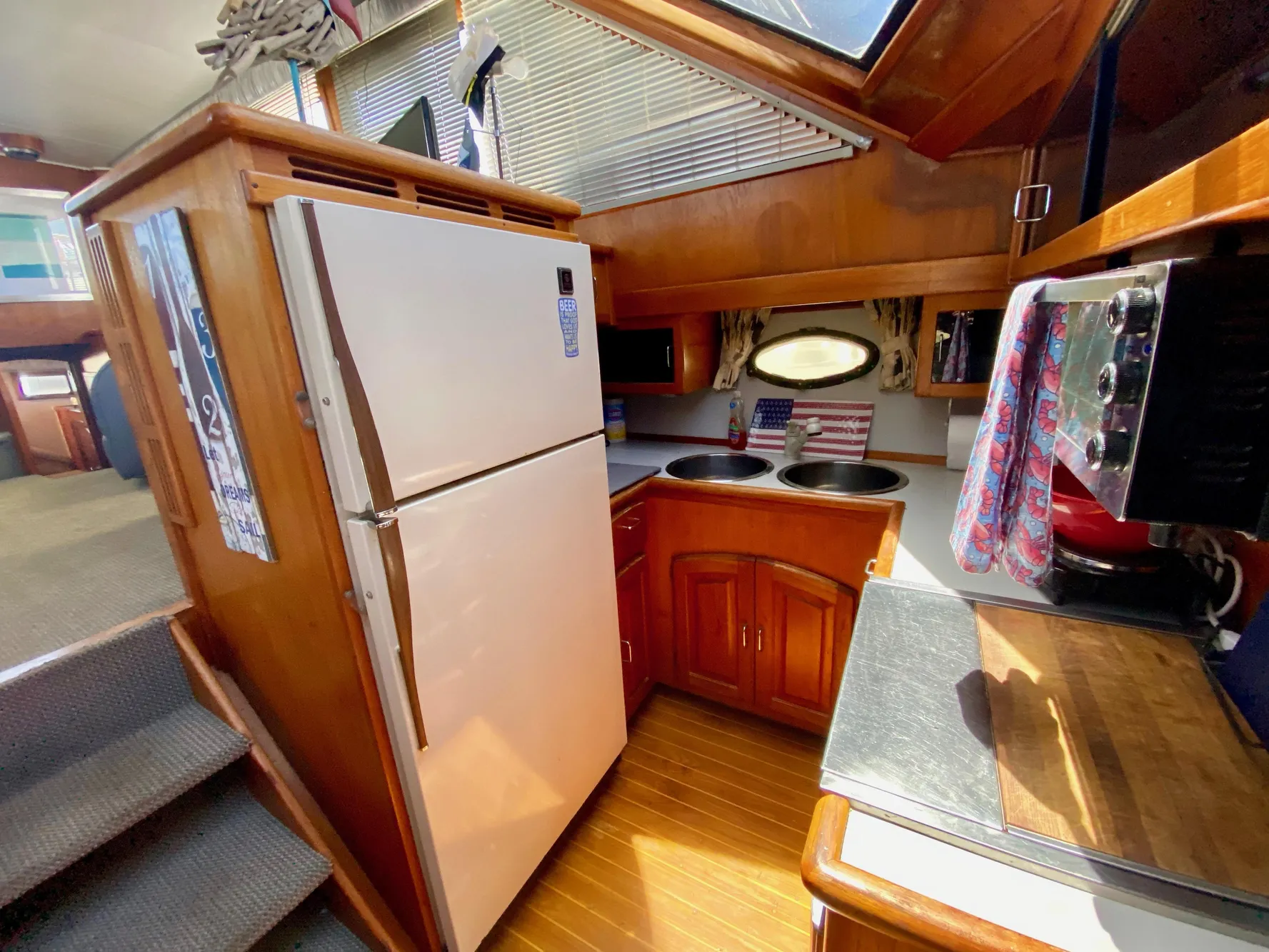 1988 Californian Sundeck Motoryacht kitchen with wood cabinetry, refrigerator, and countertop appliances.