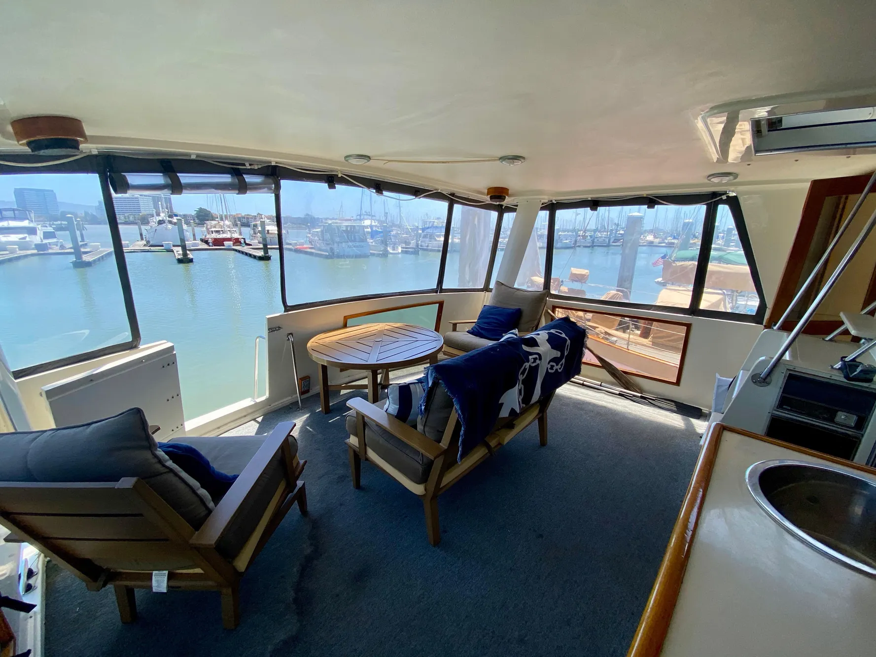 1988 Californian Sundeck Motoryacht interior with seating, table, and marina view.