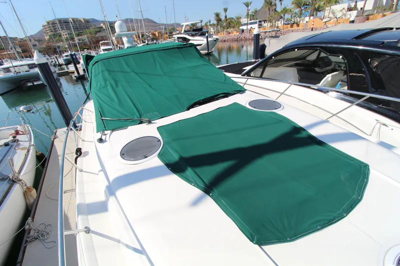  Yacht Photos Pics 2002 Regal Commodore 4260 yacht with green covers docked at a marina.
