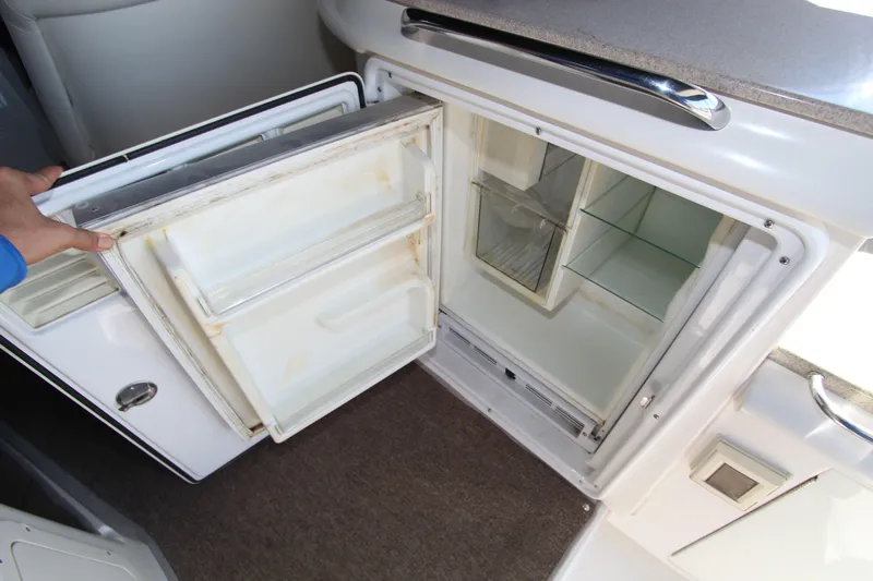  Yacht Photos Pics Open refrigerator inside 2002 Regal Commodore 4260 yacht, showing empty shelves and door compartments.