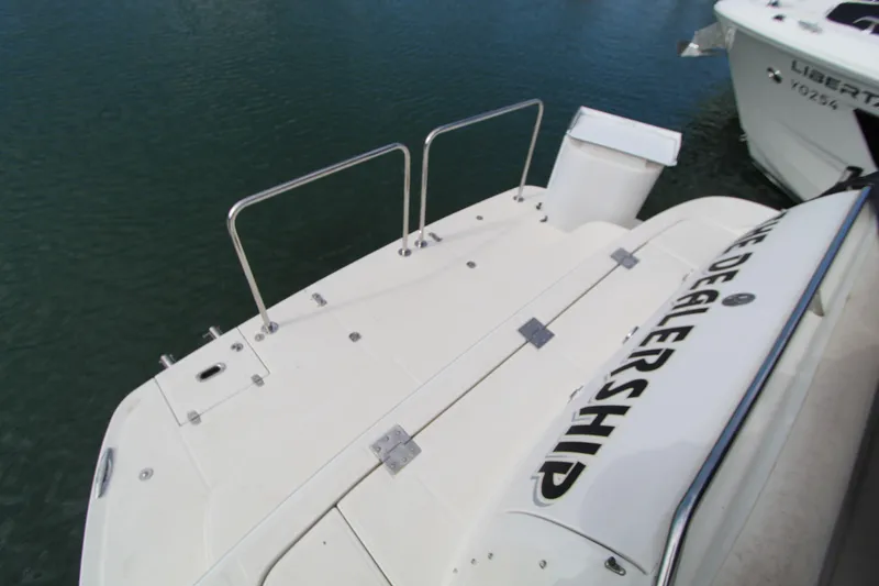  Yacht Photos Pics 2002 Regal Commodore 4260 boat deck with railing, docked on calm water.