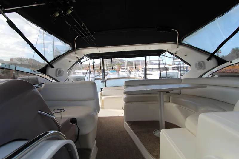  Yacht Photos Pics Interior of 2002 Regal Commodore 4260 yacht with seating and table, docked at marina.