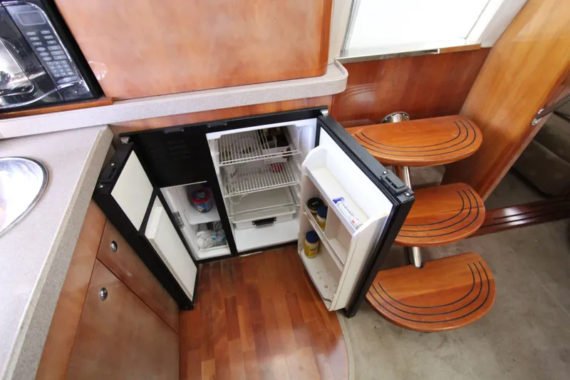  Yacht Photos Pics 2002 Regal Commodore 4260 yacht interior with open fridge and wooden steps.