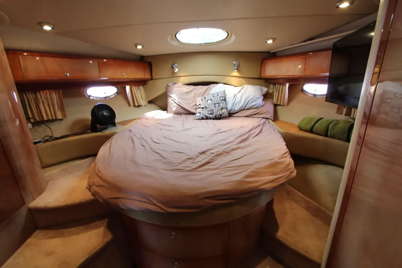  Yacht Photos Pics Luxurious cabin interior of 2002 Regal Commodore 4260 yacht with cozy bed and ambient lighting.