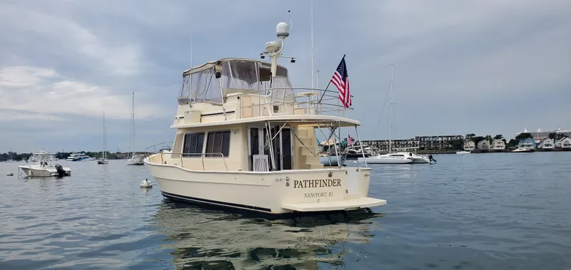 Pathfinder Yacht Photos Pics 2004 Mainship 400 Trawler on calm water, displaying American flag, Newport, RI.