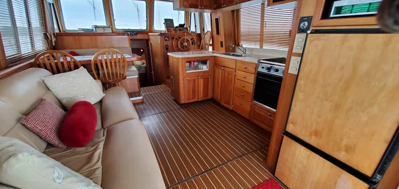Pathfinder Yacht Photos Pics 2004 Mainship 400 Trawler interior with wood finish, kitchen, seating, and helm.