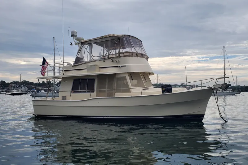 Pathfinder Yacht Photos Pics 2004 Mainship 400 Trawler yacht anchored in a serene harbor setting.