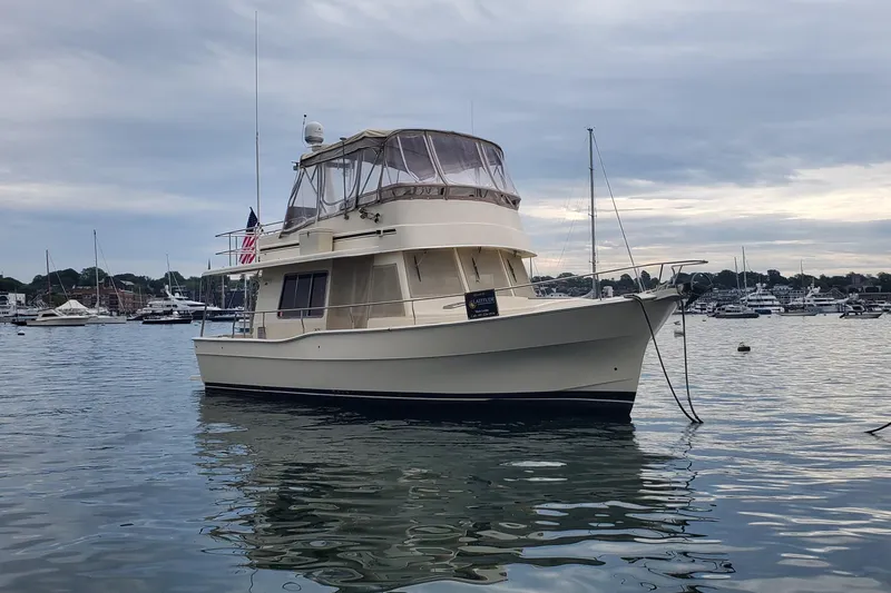 Pathfinder Yacht Photos Pics 2004 Mainship 400 Trawler anchored in a marina with overcast skies.