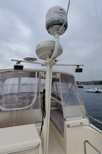 Pathfinder Yacht Photos Pics 2004 Mainship 400 Trawler with radar equipment, docked in a marina under cloudy skies.