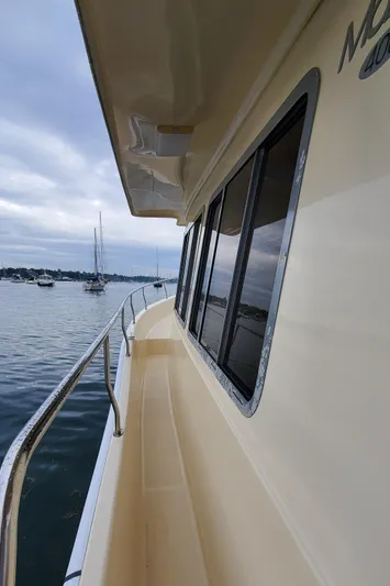 Pathfinder Yacht Photos Pics 2004 Mainship 400 Trawler side deck view with railing, overlooking calm waters and distant boats.