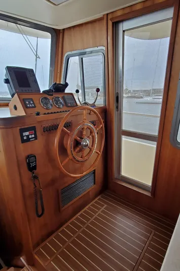 Pathfinder Yacht Photos Pics 2004 Mainship 400 Trawler helm with wooden steering wheel and navigation instruments.