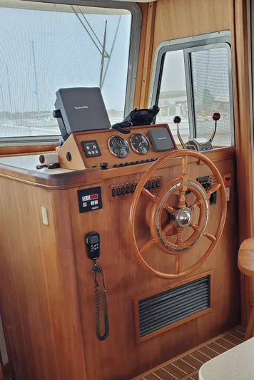 Pathfinder Yacht Photos Pics 2004 Mainship 400 Trawler helm with wooden wheel, navigation instruments, and control panel.