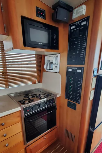 Pathfinder Yacht Photos Pics 2004 Mainship 400 Trawler kitchen with stove, microwave, and control panels.