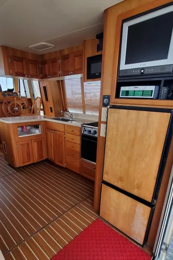Pathfinder Yacht Photos Pics 2004 Mainship 400 Trawler interior with wooden cabinetry, kitchen, and navigation area.