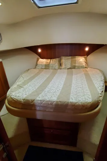 Pathfinder Yacht Photos Pics Cozy bedroom in 2004 Mainship 400 Trawler with elegant bedding and warm lighting.