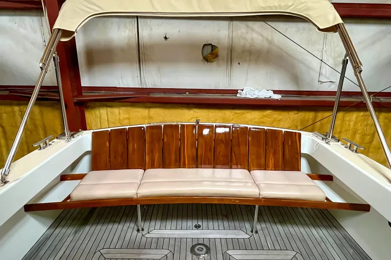  Yacht Photos Pics 2009 MJM 34z Downeast boat with wooden seating and beige cushions in a covered area.