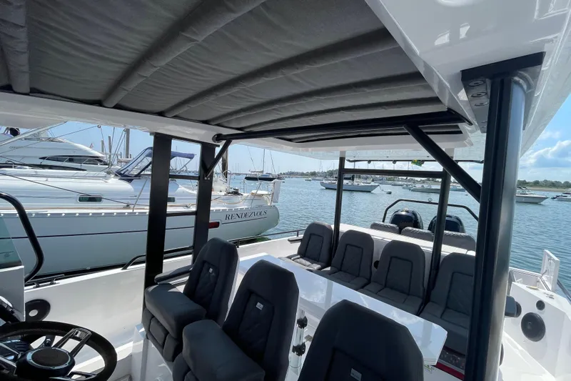 Yacht Photos Pics 2020 Axopar 37 SUN TOP BRABUS interior with seating, docked near other boats.