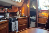 Cozy yacht interior with wooden cabinetry, kitchenette, and sleeping area, Custom Enter Explicite 360, 1999.
