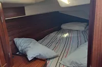 Cozy cabin interior with striped bedding in a 1999 Custom Enter Explicite 360 boat.