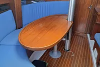 Cozy yacht interior with wooden table, blue seating, and bookshelf, Custom Enter Explicite 360, 1999.