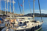 Sailboat docked in marina, Custom Enter explicite 360, 1999 model, under clear blue sky.