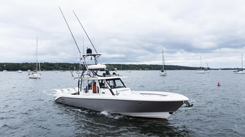  Yacht Photos Pics 2017 Everglades 435 CC boat cruising on a calm lake with sailboats in the background.